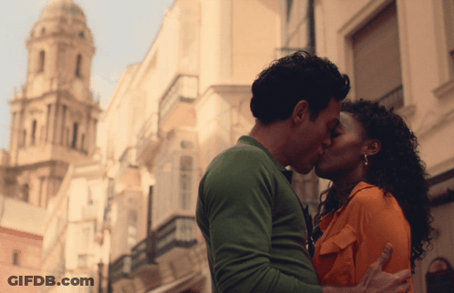 A Man And A Woman Kiss In Front Of A Building GIF