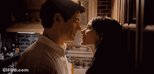 A Man And A Woman Kissing In A Kitchen . GIF