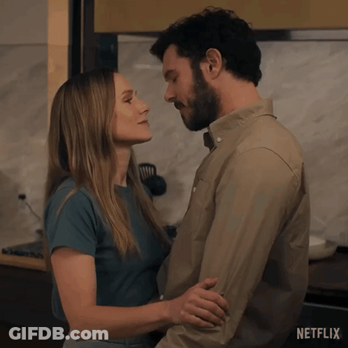 A Man And A Woman Kissing In A Kitchen With Netflix Written On The Bottom GIF