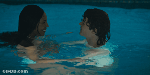 A Man And A Woman Kissing In A Swimming Pool GIF