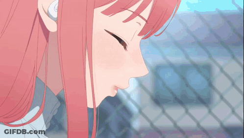 A Man And A Woman Kissing In Front Of A Fence GIF