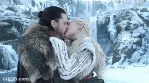 A Man And A Woman Kissing In Front Of A Waterfall . GIF