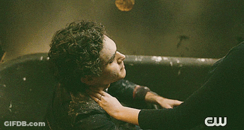 A Man And A Woman Kissing In The Rain With A Cw Logo Behind Them GIF