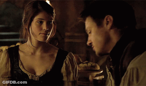 A Man And A Woman Look At Each Other In A Dark Room GIF