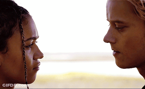A Man And A Woman Look At Each Other With Their Eyes Closed GIF