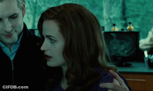 A Man And A Woman Looking At Each Other In A Dark Room GIF