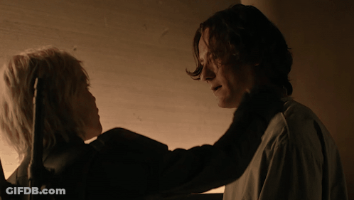 A Man And A Woman Looking At Each Other In The Dark GIF