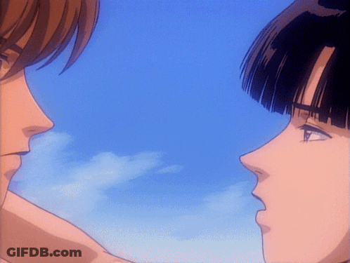 A Man And A Woman Looking At Each Other With A Blue Sky Behind Them GIF
