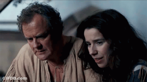 A Man And A Woman Looking At Something Together GIF