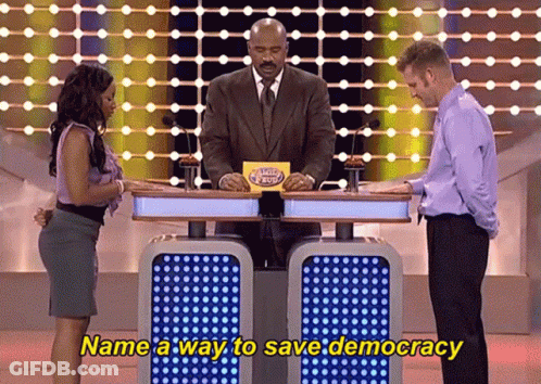 A Man And A Woman On A Game Show With The Words Name A Way To Save Democracy On The Bottom GIF