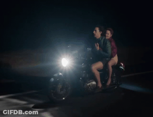 A Man And A Woman On A Motorcycle At Night GIF