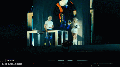A Man And A Woman On A Stage With The Word Cancella In The Lower Right Corner GIF