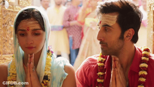 A Man And A Woman Praying In A Temple GIF