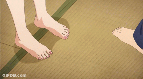 A Man And A Woman 'S Bare Feet Are Standing On A Mat GIF