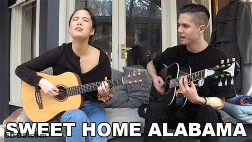 A Man And A Woman Singing Sweet Home Alabama On Guitars GIF