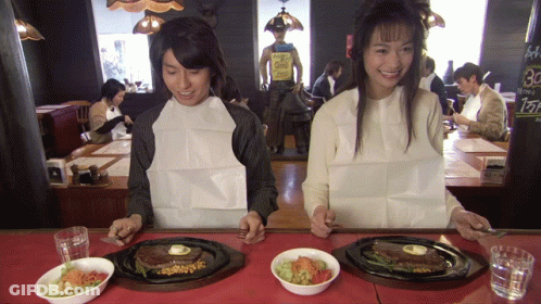 A Man And A Woman Sit At A Table With Plates Of Food And A Sign That Says 30 GIF
