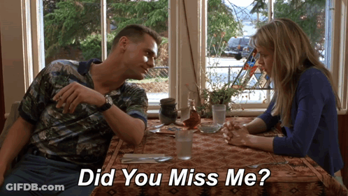 A Man And A Woman Sit At A Table With The Words " Did You Miss Me " Below Them GIF