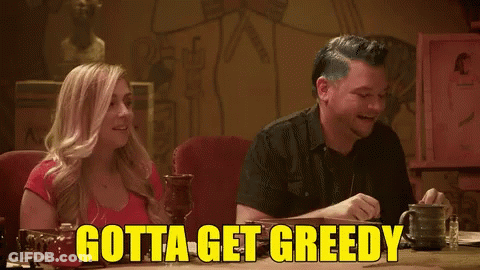 A Man And A Woman Sit At A Table With The Words Gotta Get Greedy GIF