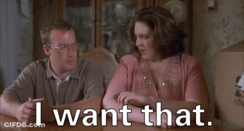 A Man And A Woman Sit At A Table With The Words I Want That GIF