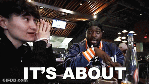 A Man And A Woman Sit At A Table With The Words It 'S About GIF