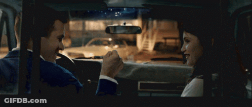 A Man And A Woman Sit In A Car Talking GIF