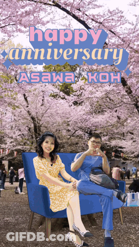 A Man And A Woman Sit On A Blue Couch In Front Of Cherry Blossom Trees And The Words Happy Anniversary GIF