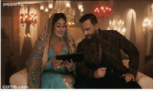 A Man And A Woman Sit On A Couch Looking At A Tablet And The Word Pepperfry Is On The Bottom GIF