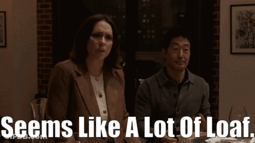 A Man And A Woman Sitting At A Table With The Words Seems Like A Lot Of Loaf Below Them GIF