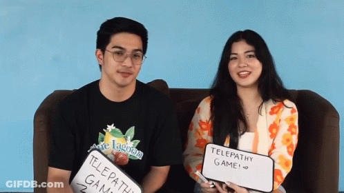A Man And A Woman Sitting On A Couch Holding Up Signs That Say Telepathy Game GIF