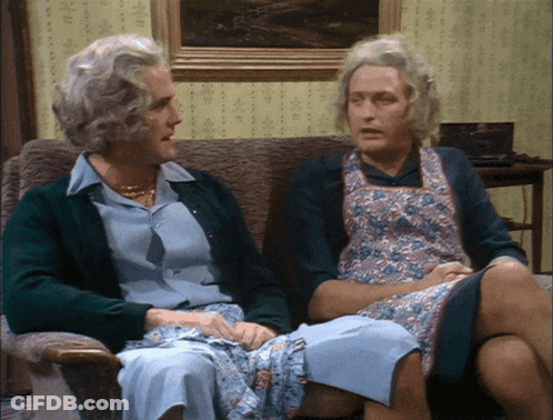A Man And A Woman Sitting On A Couch Talking GIF