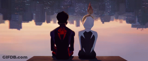 A Man And A Woman Sitting On A Ledge Looking At A City Skyline GIF