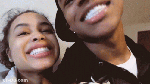 A Man And A Woman Smile For A Picture Together GIF