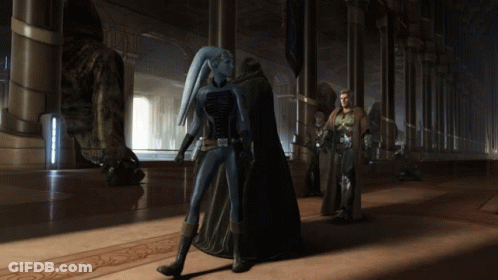 A Man And A Woman Standing In A Hallway With A Statue In The Background GIF
