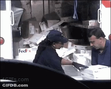 A Man And A Woman Standing In Front Of A Fedex Truck . GIF