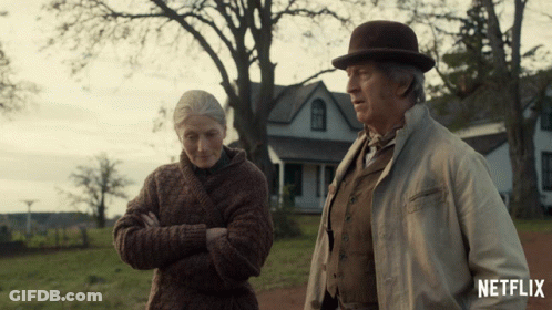 A Man And A Woman Standing In Front Of A House With A Netflix Logo On The Bottom GIF