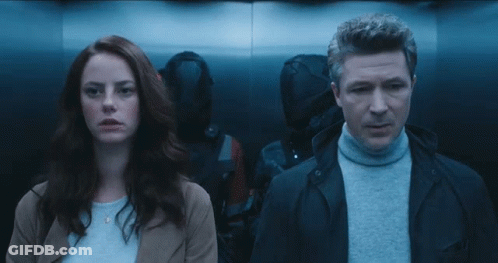 A Man And A Woman Standing Next To Each Other In A Dark Room GIF