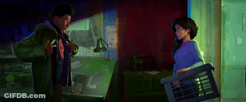 A Man And A Woman Standing Next To Each Other In A Room GIF