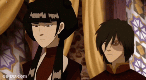 A Man And A Woman Standing Next To Each Other In A Room GIF
