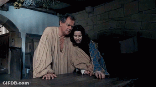 A Man And A Woman Standing Next To Each Other GIF