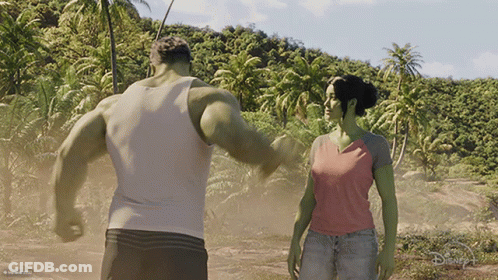 A Man And A Woman Standing Next To Each Other With A Disney Logo On The Bottom GIF