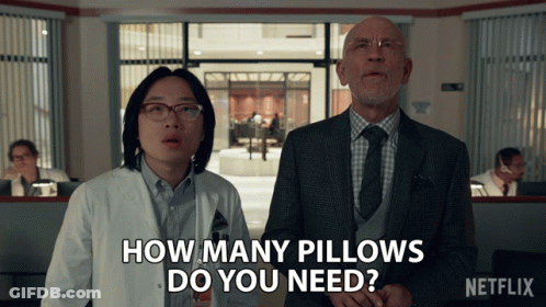 A Man And A Woman Standing Next To Each Other With The Words How Many Pillows Do You Need On The Bottom GIF