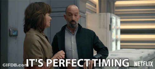 A Man And A Woman Standing Next To Each Other With The Words It 'S Perfect Timing Netflix GIF