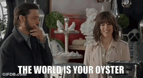 A Man And A Woman Standing Next To Each Other With The Words " The World Is Your Oyster " Behind Them GIF