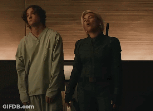 A Man And A Woman Standing Next To Each Other GIF