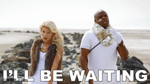 A Man And A Woman Standing On A Beach With The Words " I 'Ll Be Waiting " Below Them GIF