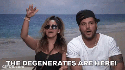 A Man And A Woman Standing On A Beach With The Words " The Degenerates Are Here " Behind Them GIF