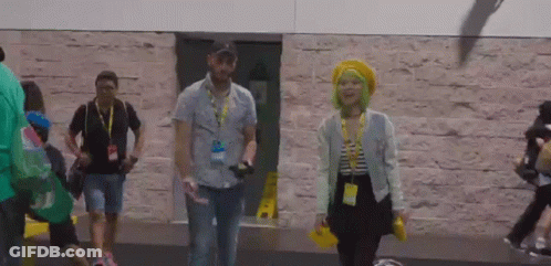 A Man And A Woman Walking In Front Of A Building GIF