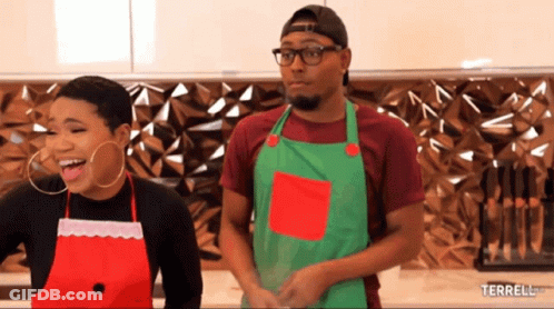 A Man And A Woman Wearing Aprons Are Standing Next To Each Other With The Words Terrell.com Below Them GIF