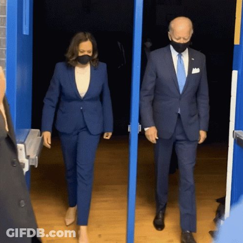 Man And Woman Wearing Masks Walking Out Doorway GIF