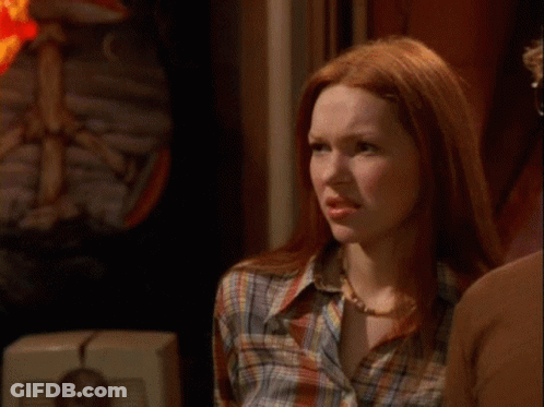 A Man And A Woman With Red Hair Are Standing Next To Each Other GIF